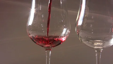 Pouring red wine into two elegants glasses Stock Footage 104048275