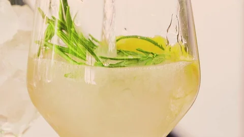 Pouring refreshing alcohol drink with bubbles, ice, lemon lime, gin tonic, soda. Stock Footage 128818464