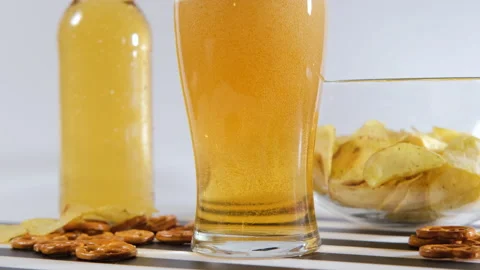 Pouring refreshing beer with salty snacks nearby Vídeo Stock 296215282