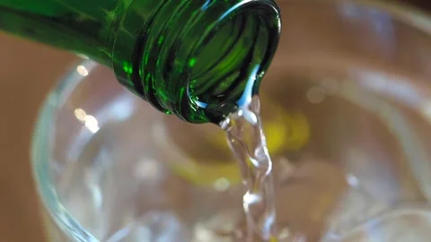 Pouring a Refreshing Beverage into a Glass Filled with Ice Cubes for Enjoyment Vidéo 296292102