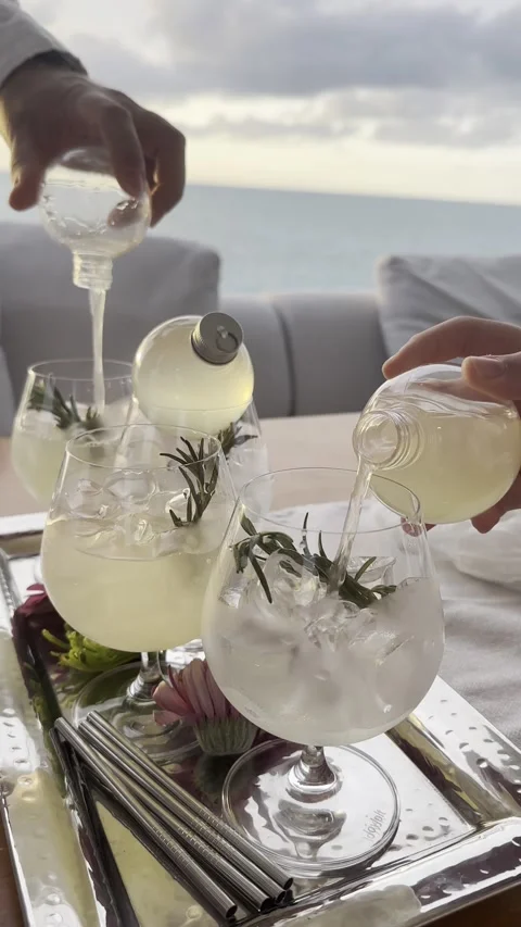 Pouring refreshing lemonade over ice by the ocean on a sunny day Stock Footage 318045059