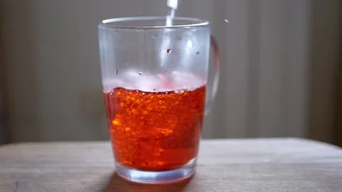 Pouring Refreshing Red Liquid into a Clear Glass Stock-Footage 316176564