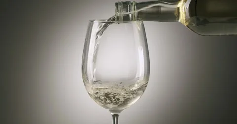 Pouring refreshing white wine into a glass in slow motion Stock Footage 342737105