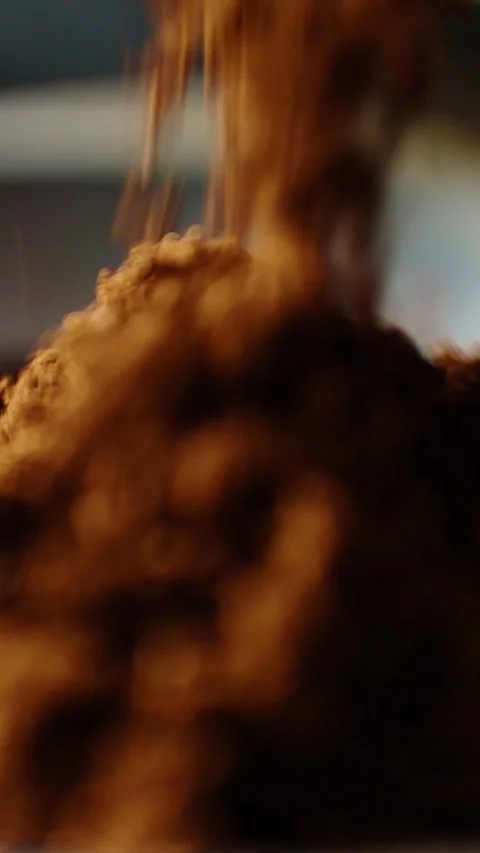 Pouring rich brown coffee grounds into a brewing pot in a cozy kitchen setting Stock Footage 342798072