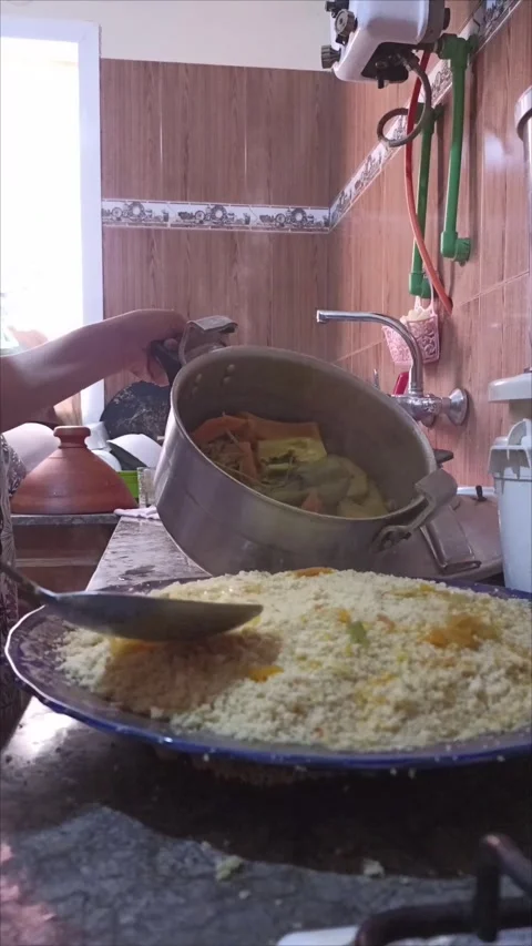 Pouring Rich Vegetable Broth Over Traditional Moroccan Couscous Video stock 333865958