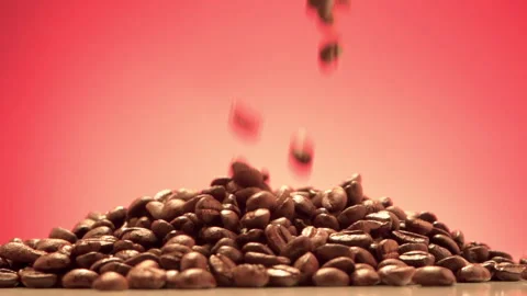 Pouring roasted coffee beans to table red background slow motion 100fps Video stock 156251964