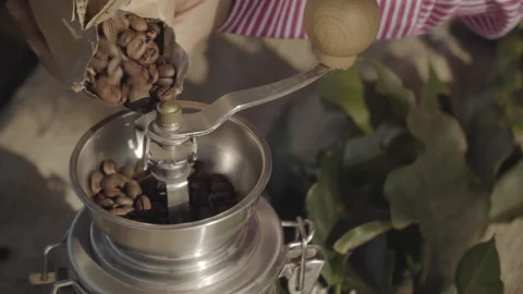Pouring roasted coffee from rustic packaging in manual grinder Stock Footage 164093333