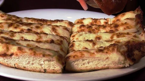Pouring sauce on Mozzarella breadsticks Stock-Footage 105983512