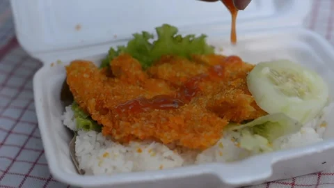 Pouring Sauce over Crispy Chicken Katsu Rice Box Stock Footage 344880611