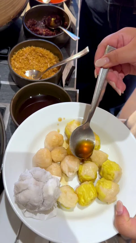 Pouring Sauce Over Steamed Dim Sum Dumplings and Pork Buns Stock Footage 334698214
