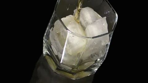 Pouring a scotch whiskey into glass with ice Stock Footage 51805341
