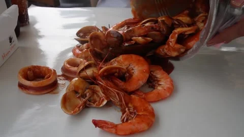 Pouring seafood bucket on to the table Stock Footage 251707340