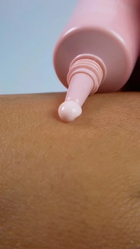 Pouring a small amount of pink moisturizing cream onto skin from bottle Stock Footage 338279046