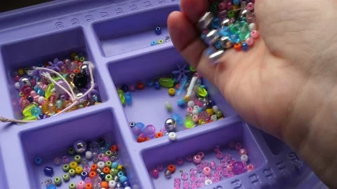 Pouring small decorative beads into plastic container Stock Footage 134287761