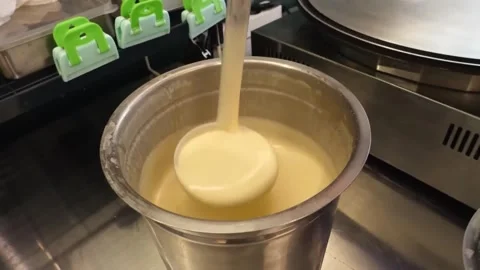 Pouring Smooth Batter with a Ladle in a Professional Kitchen Stock Footage 345691886