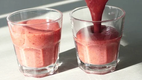 Pouring smoothie in two glasses Stock Footage 72714538