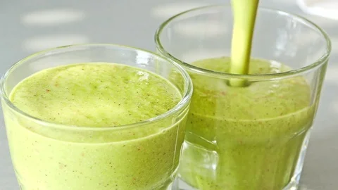 Pouring smoothie in two glasses Stock Footage 72936443