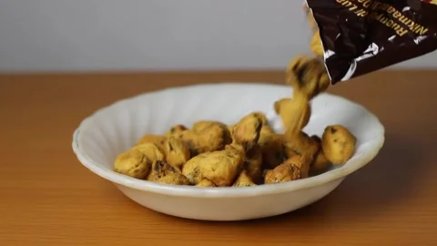 Pouring snacks into a plate Stock Footage 321984076