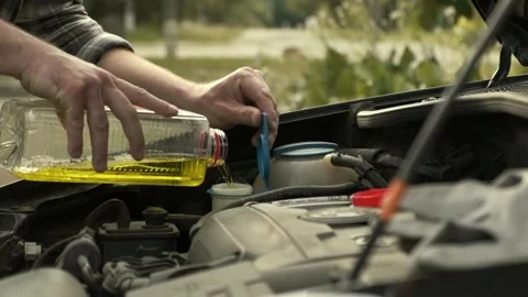 Pouring some windshield washer fluid in the special compartment Stock Footage 243100605