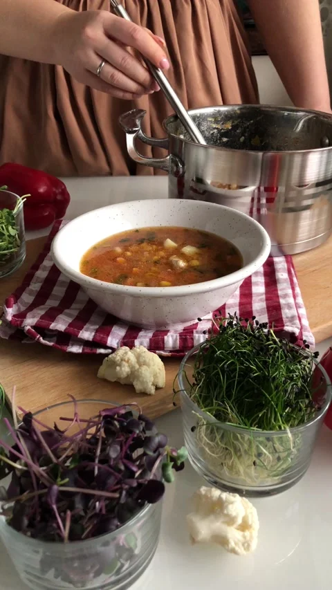 Pouring soup from a pot into a plate using a ladle Stock Footage 142640663