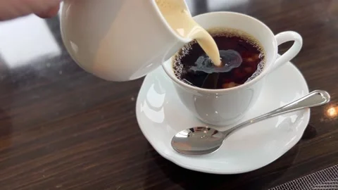 Pouring Soy Milk Into A Cup of Black Coffee Stock Footage 345533408