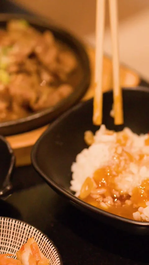 Pouring Soy Sauce Over Cured Egg Yolk and Rice with Chopsticks Stock Footage 344948905