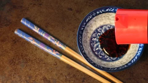 Pouring Soy Sauce from Red bottle into Blue Dish for Sushi dinner 動画素材 126088041