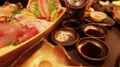Pouring soy sauce into small dipping bowls for delicious sashimi and seafoo.. Stock Footage 333107922