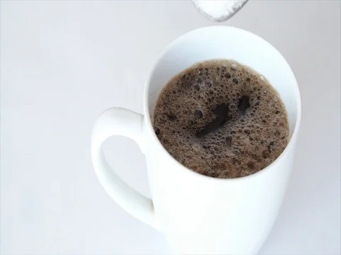 Pouring spoon sugar into white coffee morning cup Stock Footage 76509032