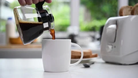 Pouring steaming coffee in to a cup in the kitchen Video stock 154615386