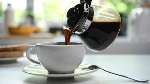 Pouring steaming coffee in to a cup in the kitchen Stock Footage 154615387