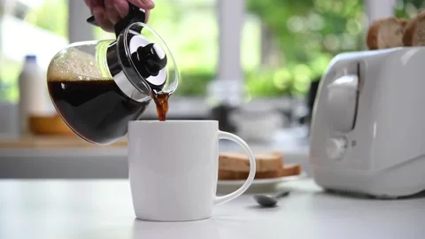 Pouring steaming coffee in to a cup in the kitchen Stock Footage 154615389