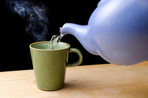 Pouring steaming hot tea in a cup Stock Photos