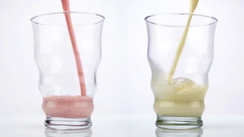Pouring Strawberry and Vanilla Milkshakes into a Glass Stock Footage 123722575