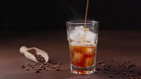 Pouring stream of Coffee into a empty glass with Ice Cubes Stock Footage 238086390
