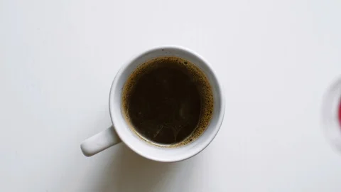 Pouring stream milk from bottle into a cup of black coffee. Stock Footage 104557142