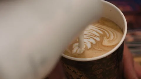 Pouring stream milk into a cup of espresso, slow motion Stock Footage