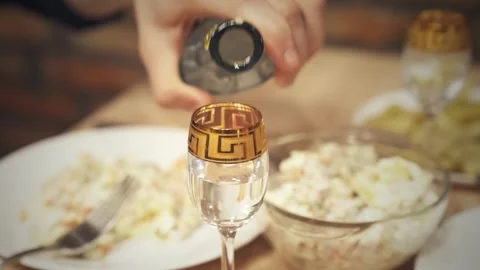 Pouring strong alcoholic drink into elegant shot glass during festive dinner. Stock Footage 345447808