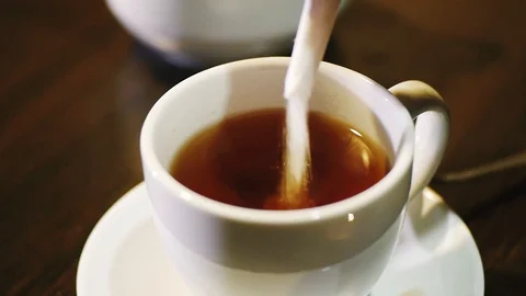 Pouring sugar into a cup of tea Stock Footage 86100041