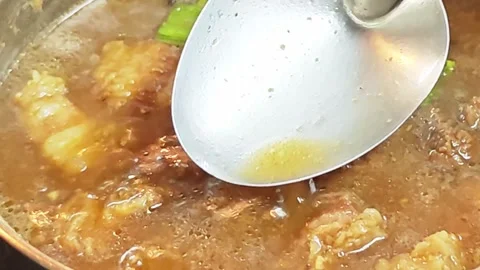 Pouring sweet and savory five-spice stew sauce with a ladle. 動画素材 344561720