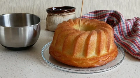 Pouring the syrup over the rum baba. Rum-soaked circular cake Vidéo 153520669