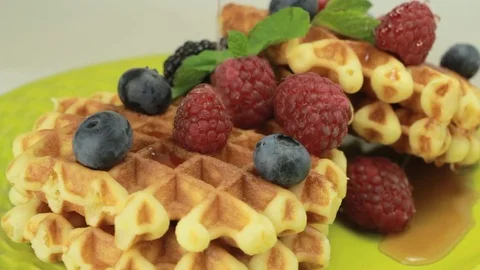 Pouring syrup onto waffles with berries Stock Footage 80646998