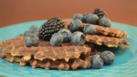 Pouring syrup onto waffles with berries Stock Footage