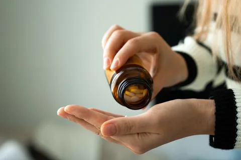 Pouring tablets from bottle into hand Stock Photos