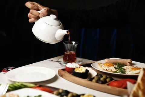 Pouring tea and serving breakfast in a restaurant setting Stock Photos