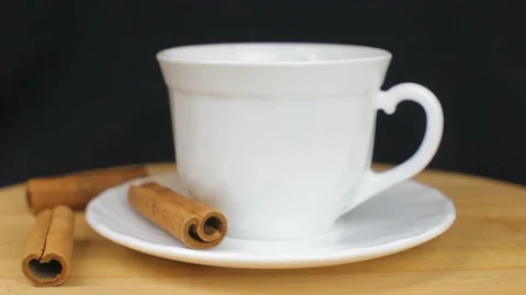 Pouring Tea with Cinnamon on Black Background on Wooden Plate Stock Footage 86857062