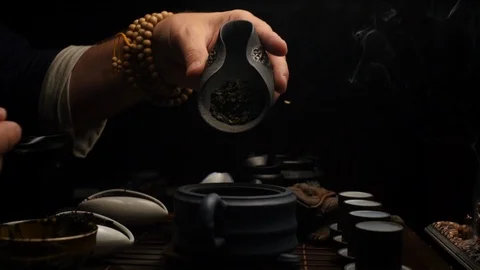 Pouring tea into a clay teapot is another way Stock Footage 107822424
