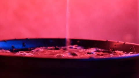 Pouring tea into a Cup in neon light Stock Footage 115253652