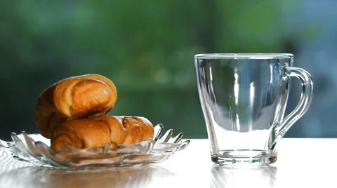 Pouring Tea in a cup next to breakfast pastries Video stock 50055040