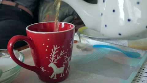 Pouring tea in a cup with a teapot Video stock 147288597
